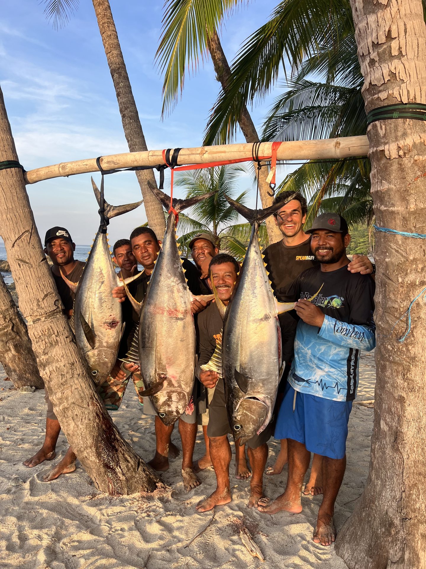 Spearbaby crew with yellowfin tuna catch on the beach